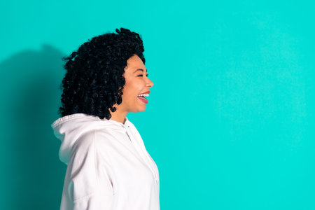 Side profile photo of young funny chevelure hair brunette lady looking curious laughing isolated on aquamarine color backgroundの写真素材