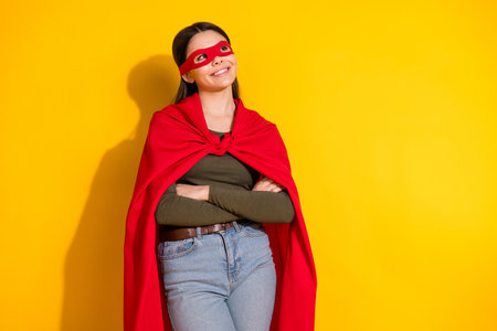 Photo portrait of pretty teenager girl look empty space superman confident wear trendy khaki outfit isolated on yellow color backgroundの写真素材