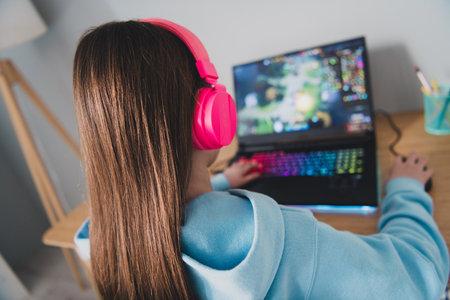 Photo of confident lovely adorable girl little gamer playing online video computer game indoors houseの写真素材