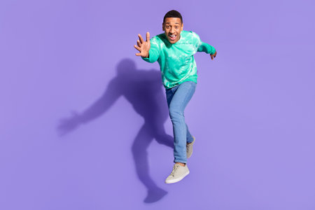 Full length photo of cheerful positive guy dressed turquoise sweatshirt jumping running emtpy space...
