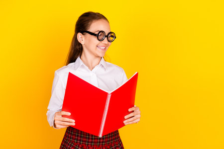 Photo portrait of charming teenager pupil girl read book look empty space wear trendy uniform...