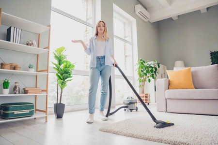 Photo of unhappy tired girl dressed casual shirt dislike vacuum cleaning home indoors house apartment roomの写真素材