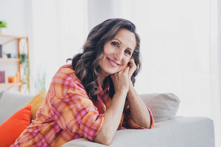 Photo of adorable sweet lady wear plaid shirt smiling having rest couch indoors room home houseの写真素材