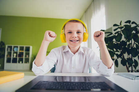 Photo portrait of cute preteen schoolboy headphones winning celebrate online lesson home education...