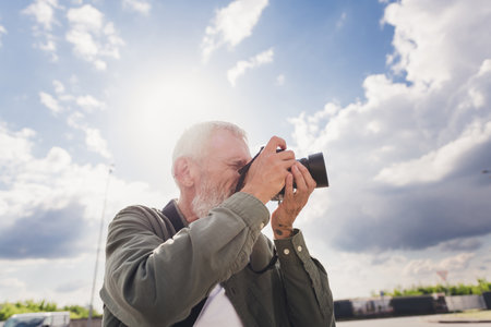Photo of funky cool mature guy dressed casual shirt enjoying photographing outdoors urban city...