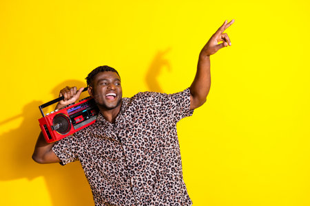 Photo of attractive cheerful man wear trendy leopard print clothes listen music empty space isolated...