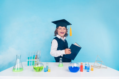 Photo of cheerful clever intelligent boy prepare chemical experiment isolated on blue color...