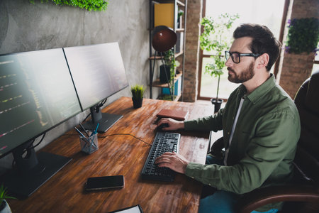 Photo of clever nice intelligent man software expert wear shirt work with operating system server pc netbook indoorsの写真素材