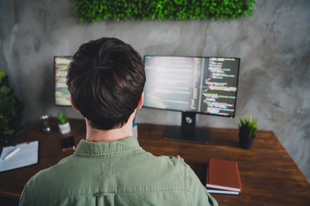 Rear view back side photo of man hardware expert work with modern technology operating system workspace indoorsの写真素材