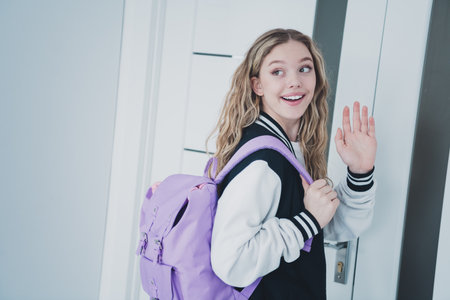 Photo of sweet pretty teen girl exit room wave hand bye wear stylish school uniform morning routine...