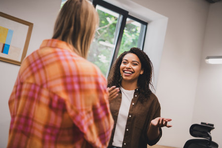 Photo of two young corporate businesswomen talk coworking loft interior office indoorsの写真素材
