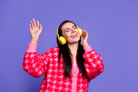 Photo of adorable lovely girl wear pink cardigan headphones singing songs empty space isolated purple color backgroundの写真素材