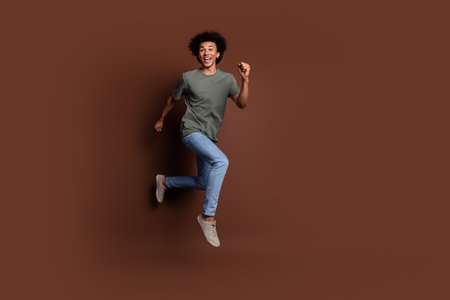 Full size photo of nice young guy running hurry black friday wear trendy khaki outfit isolated on brown color backgroundの写真素材