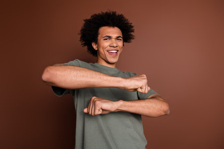 Photo portrait of handsome young male dancing discotheque dressed stylish khaki garment isolated on brown color backgroundの写真素材