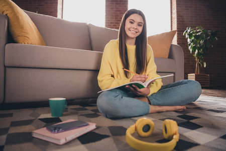 Full body photo of nice teen girl sit floor do homework write textbook wear yellow clothes modern...