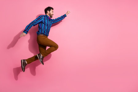 Full length photo of crazy cheerful man wear stylish clothes fly air empty space isolated on pink...