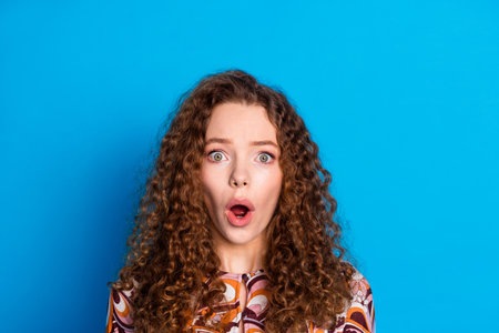 Photo portrait of lovely young lady shocked frightened dressed stylish colorful garment isolated on blue color backgroundの写真素材