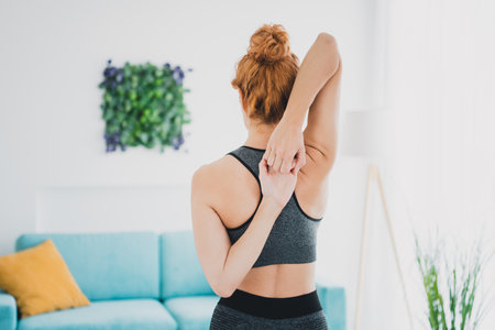 Photo of athletic healthy woman doing fitness physical exercises home gym indoors