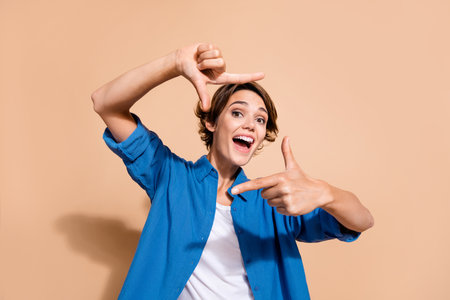 Photo portrait of lovely young lady show cheerful frame fingers gesture wear trendy blue garment...