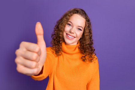 Photo of lovely young girl show thumb up wear sweater isolated on violet color background