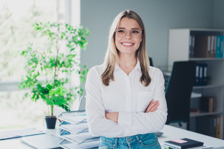 Portrait of professional corporate worker lady folded arms contemplate modern office indoorsの写真素材