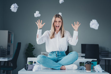 Full body portrait of professional corporate worker lady sit desk throw paper modern office indoors