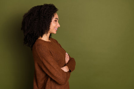 Profile portrait of pretty young woman crossed arms empty space wear sweater isolated on khaki color...