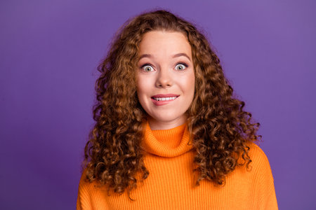 Portrait photo of wavy red hair young woman bite lips excited in orange stylish turtleneck good mood...
