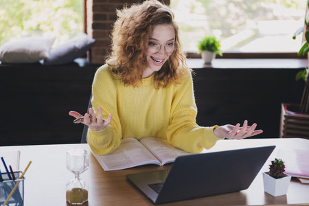 Photo of cute young female working video call netbook wear yellow sweater comfortable modern loft...