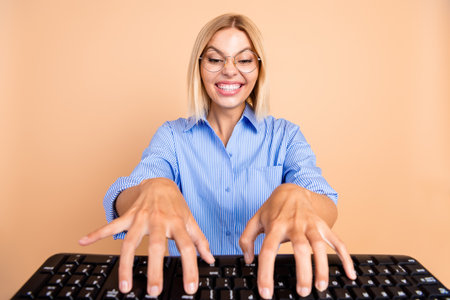 Photo of funky carzy girl wear blue shirt typing modern device empty space isolated beige color backgroundの写真素材
