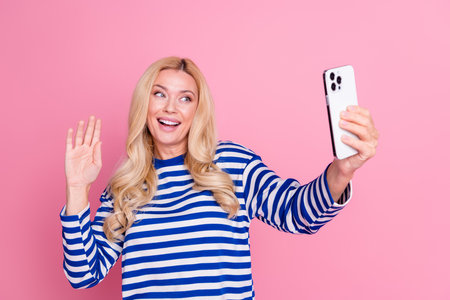 Photo of cheerful lovely cute woman wear stylish striped clothes blog video record live stream isolated on pink color backgroundの写真素材