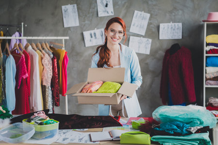 Photo of pretty elegant clothing designer woman hold clothes order box loft interior office indoorsの写真素材