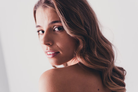 Photo of lovely young lady turn around look camera no retouch bare shoulders isolated on gray color backgroundの写真素材