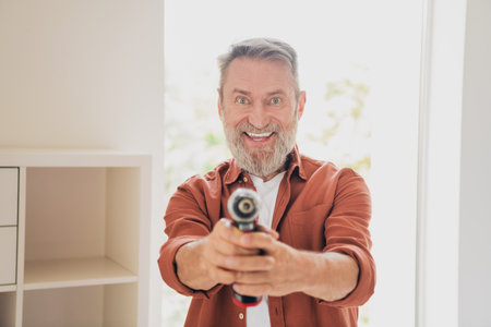 Photo of senior male fix install shelf drill excited repairman dressed brown outfit cozy day light...