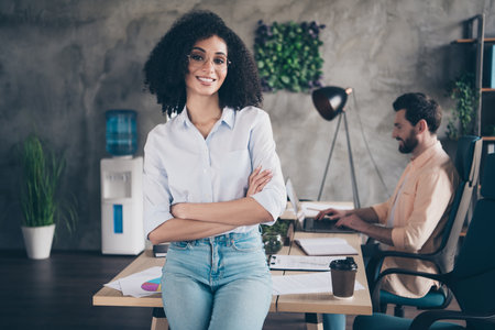Portrait of two young corporate workers crossed arms start up modern loft interior office indoorsの写真素材
