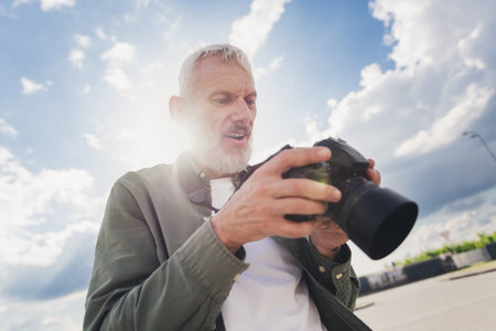 Photo of handsome good mood seniour guy wear green shirt taking camera pictures outdoors urban city...