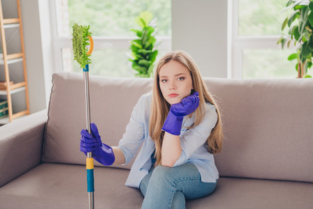 Photo of stressed cute girl dressed casual shirt dislike desinfecting home indoors house apartment...