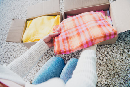 Photo of retired woman dressed white cardigan sitting floor packing parcel package relocation moving indoorsの写真素材