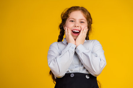 Photo portrait of charming little pupil girl excited reaction touch cheeks wear trendy uniform...