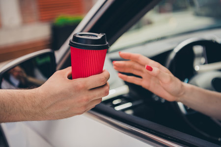 Cropped photo of lady driver hands arms riding car buying coffee to go outdoors urban city streetの写真素材