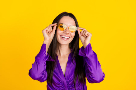 Photo of positive smiling lady touch sunglass isolated bright color backgroundの写真素材
