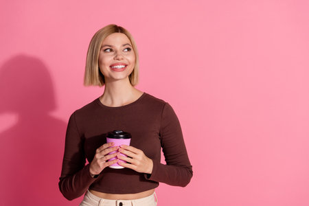 Photo of lovely pretty cute girl wear trendy brown clothes hold tasty coffee empty space isolated on...