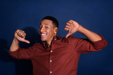 Portrait of young man point fingers self wear brown shirt isolated on dark blue color background