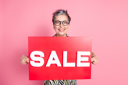Photo of nice aged woman hands hold sale placard wear zebra print shirt isolated on pink color backgroundの写真素材