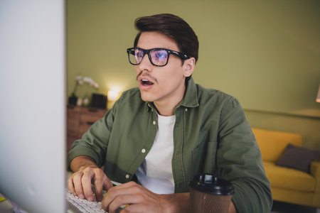 Photo of attractive adult man sit table work from home cozy interior room apartment workplace...