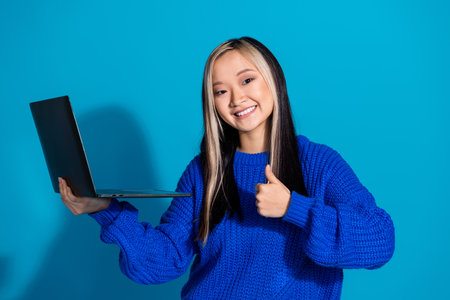 Photo of korean working remote young girl with laptop thumb up like symbol for updated device...