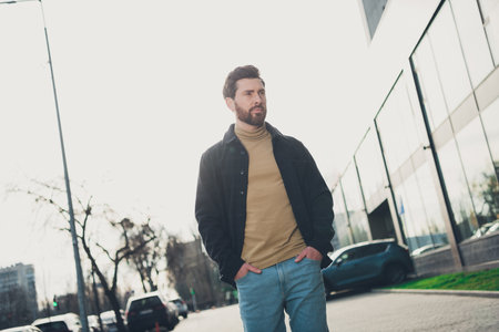 Photo of successful attractive man wear stylish clothes going big city street autumn day weatherの写真素材