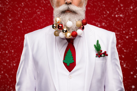 Cropped photo of old serious cool man wear beard balls christmas decor suit isolated on red color backgroundの写真素材
