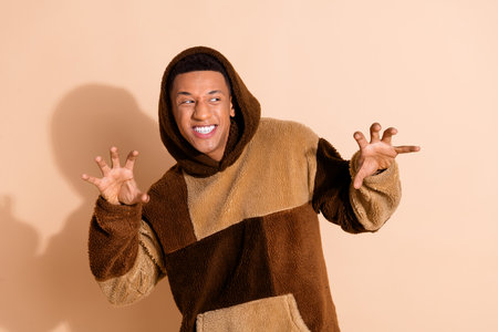 Photo of good mood guy with stylish haircut dressed plush hoodie look at event promo empty space...