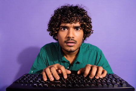 Closeup photo funny arabian programmer nervous looking in pc screen tapping keyboard wearing green...
